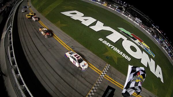 Denny Hamlin (11) collects the checkered flag during a wild finish of the Monster Energy NASCAR Cup Series 61st Annual Daytona 500 Sunday, Feb. 17, 2019, at Daytona International Speedway in Daytona Beach, Fla.