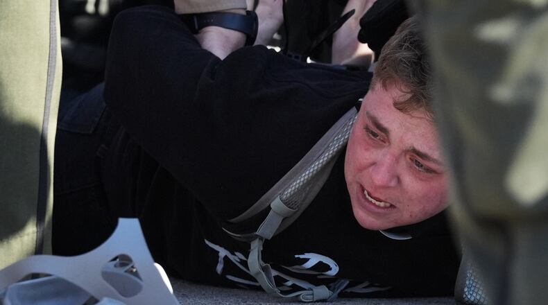Illinois State police detain a protester outside an ICE processing facility in the Chicago suburb of Broadview, Ill., Friday, Nov. 14, 2025. (AP Photo/Nam Y. Huh)