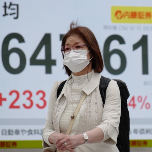 A person walks in front of an electronic stock board showing Japan's Nikkei index at a securities firm Tuesday, April 7, 2026, in Tokyo. (AP Photo/Eugene Hoshiko)