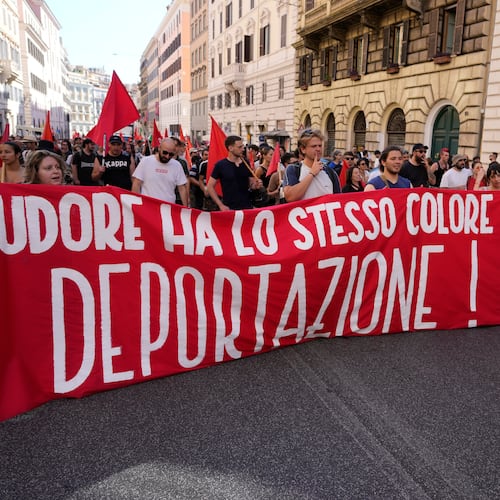 People hold a banner in Italian reading "Skin and sweat have the same color, no deportation' during a march in Rome, Saturday, June 13, 2026, to protest Italy's security and migration package, including a migrant "repatriation bonus" scheme criticized by opposition parties and legal groups as unconstitutional and ethically problematic. (AP Photo/Gregorio Borgia)