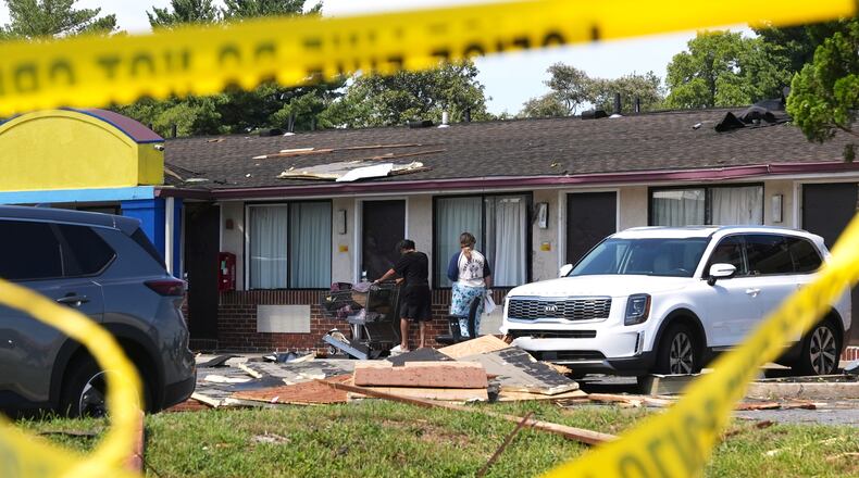 Hotel residents return to the tornado-damaged Days Inn by Wyndham Dover Downtown hotel after picking up food and supplies Friday, Aug. 21, 2026, in Dover, Del. (AP Photo/Mingson Lau)