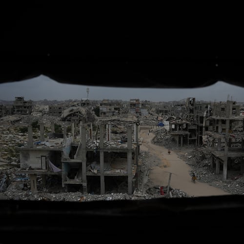 Palestinians walk through the destruction left by the Israeli air and ground offensive in Jabaliya, northern Gaza Strip, Saturday, Dec. 6, 2025. (AP Photo/Abdel Kareem Hana)