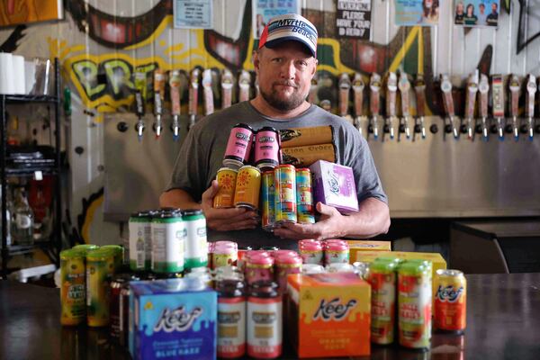 Scofflaw Brewery co-founder Matt Shirah holds an assortment of THC-infused drinks offered at the brewery on Wednesday, July 16, 2025. (Natrice Miller/ AJC)