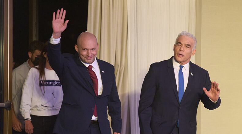Former Israeli prime ministers Naftali Bennett, left, and Yair Lapid arrive to a joint press conference announcing that their parties will run together in the upcoming elections, in Herzliya, Israel, Sunday, April 26, 2026. (AP Photo/Ariel Schalit)