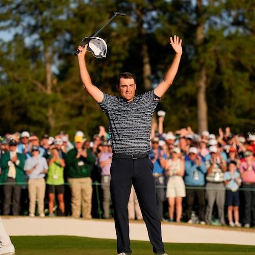 FILE - Cameron Smith, of Australia, walks past as Scottie Scheffler celebrates after winning the 86th Masters golf tournament on April 10, 2022, in Augusta, Ga. (AP Photo/Matt Slocum, File)
