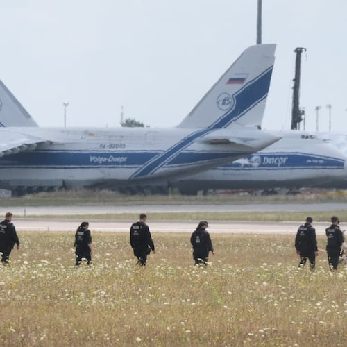 Police officers are walking across a field on the grounds of Leipzig Airport, in Schkeuditz, Germany, Friday, Aug. 7, 2026, searching for a drone that may be connected to a suspected attack. (Sebastian Willnow/dpa via AP)