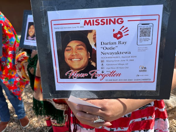 Family members hold signs showing Darian Nevayaktewa, who went missing in 2008, while they mark Missing and Murdered Indigenous Persons Awareness Day during an event in Albuquerque, New Mexico, on Monday, May 5, 2025. (AP Photo/Susan Montoya Bryan)
