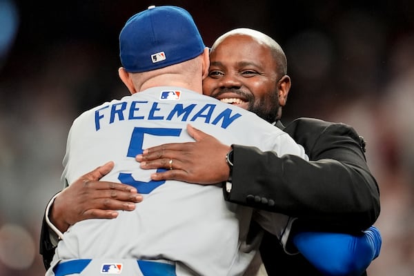 Former Brave Freddie Freeman hugs tenor Timothy Miller (Atlanta's beloved "God Bless America" singer) in the seventh inning of Sunday's game at Truist Park.