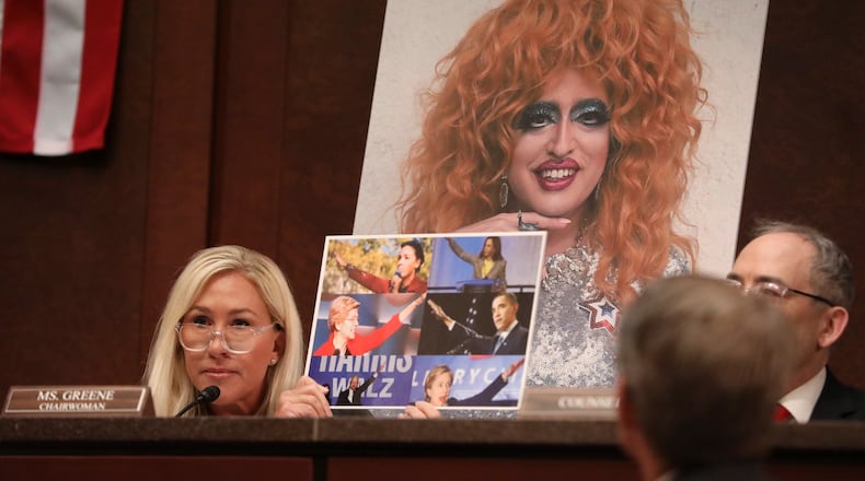 Rep. Marjorie Taylor Greene (R-Ga.) holds up an image of Democrats with their arms raised during a hearing of the House Committee on Oversight and Government Reform subcommittee on Delivering Government Efficiency on Capitol Hill in Washington, on Wednesday, March 26, 2025. (Anna Rose Layden/The New York Times)