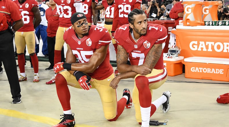 The San Francisco 49ers' Colin Kaepernick, right, and Eric Reid kneel in protest during the national anthem prior to playing the Los Angeles Rams at Levi's Stadium on Sept. 12, 2016, in Santa Clara, California. (Thearon W. Henderson/Getty Images/TNS)