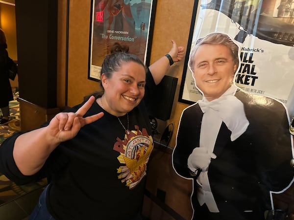 At the Tara Theatre, Cineprov cast member Candace Weslosky poses with a cardboard cutout of the late theater owner George Lefont, who used to own both the Plaza and the Tara. Weslosky also runs the “Rocky Horror Picture Show” acting troupe that performs weekly at the Plaza. “I remember George taking a chance on ‘Rocky’ and the fact we are here at the Tara is important to me,” Weslosky said. (Rodney Ho/AJC)