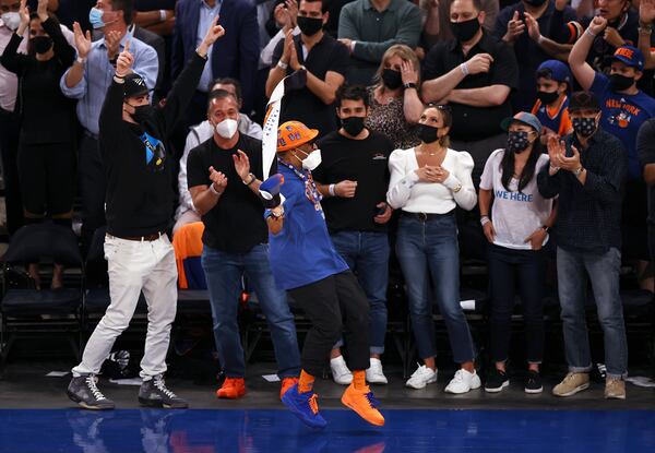 Spike Lee, in orange hat, celebrates late in the fourth quarter of Game 2 in an NBA basketball first-round playoff series between the Atlanta Hawks and the New York Knicks on Wednesday, May 26, 2021, in New York. (Elsa/Pool Photo via AP)