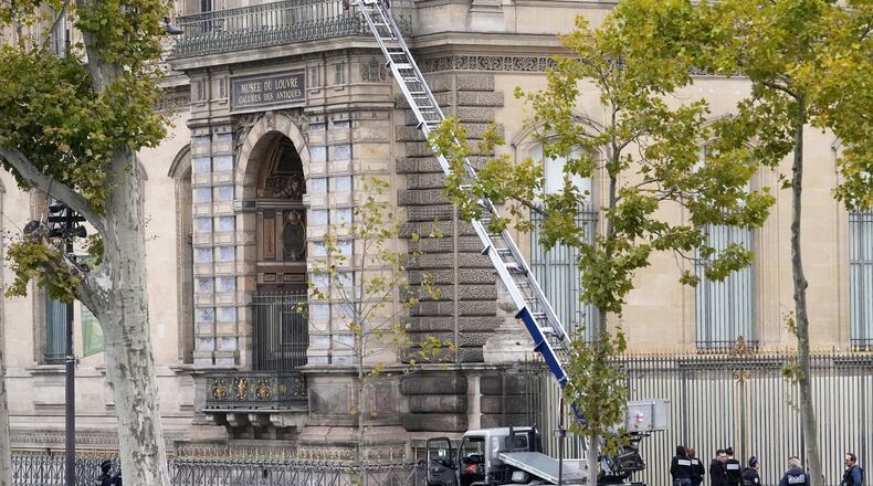 Police officers work by a basket lift used by thieves Sunday, Oct. 19, 2025 at the Louvre museum in Paris. (AP Photo/Thibault Camus)