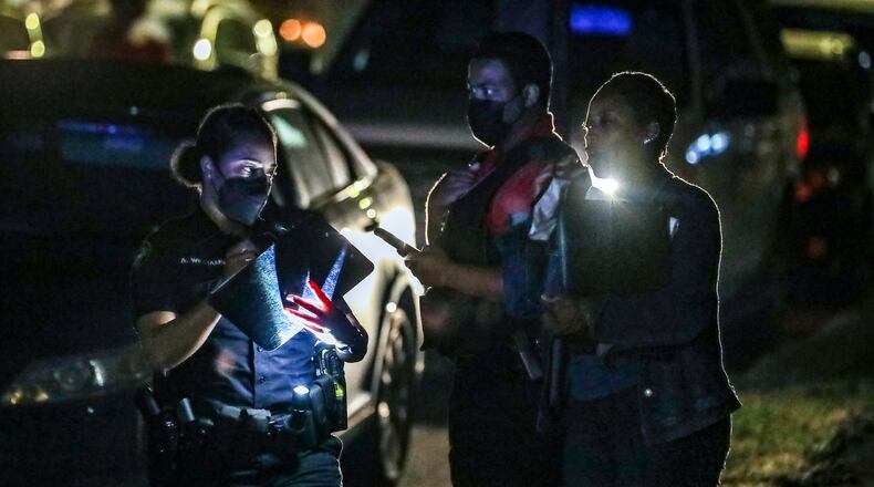 Atlanta police (left) speak with Fulton County D.A. investigators (right) at the scene. Atlanta police and Fulton County investigators are working to determine what led to a deadly shooting Thursday morning, Sept. 30, 2021 in southwest Atlanta. (John Spink / John.Spink@ajc.com)