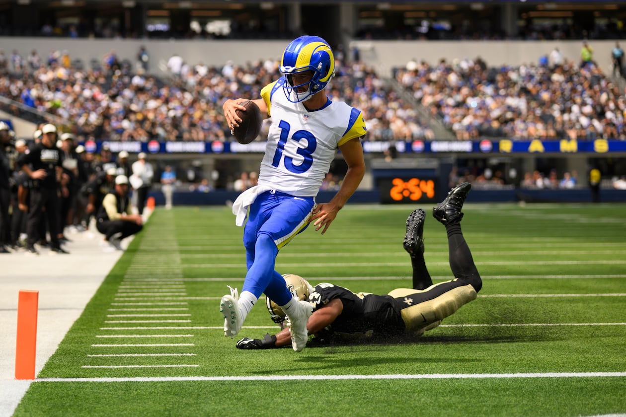 Rams quarterback Stetson Bennett IV (left) runs past Saints linebacker Isaiah Stalbird for a touchdown Saturday, Aug. 22, 2026, in Inglewood, Calif. Bennett was 19-for-31 for 181 yards passing and two rushing TDs. (Kyusung Gong/AP)