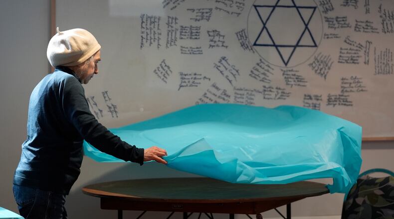Volunteer Marlene Ring spreads a table cloth while preparing a room for a passover meal Monday, March 30, 2026, at the Beth Israel Synagogue in Waterville, Maine. (AP Photo/Robert F. Bukaty)