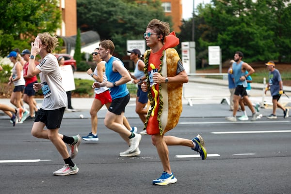 A runner wearing a hot dog costume competes on Hope Hill during the Peachtree Road Race on Saturday, July 4, 2026, in Atlanta. (Estela Muñoz/AJC)
