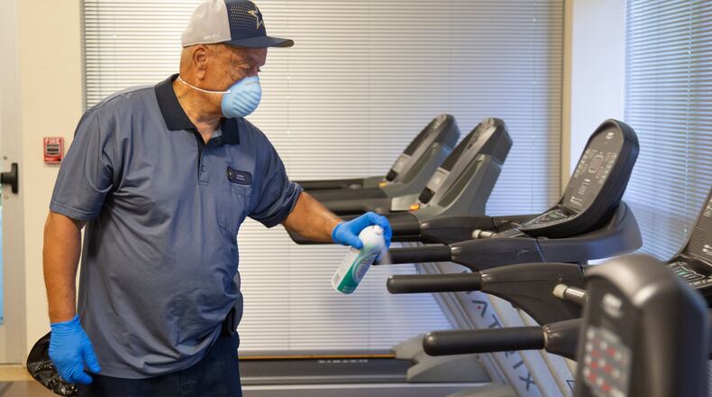 Keith Smith sprays sanitizer on the athletic equipment at the Frank Bailey Senior Center during the county’s deep cleaning and sanitizing of the building in preparation for the upcoming public reopening. STEVE SCHAEFER / SPECIAL TO THE AJC
