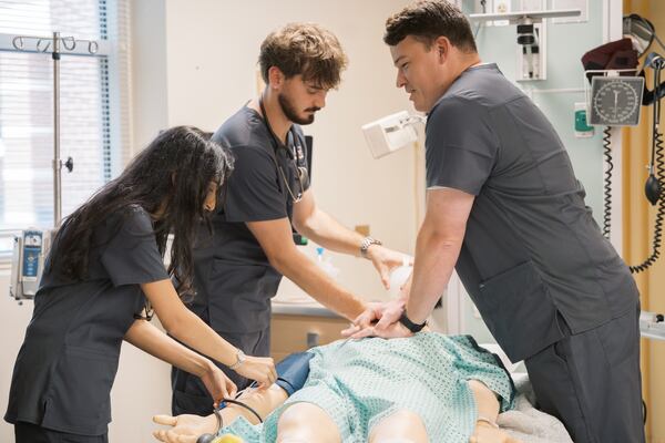 Mercer University nursing students Insha Dodhia, Joshua Bishop and Nicholas Petroni practice clinical skills in the university's simulation lab in Atlanta. (Courtesy of Marin Guta)