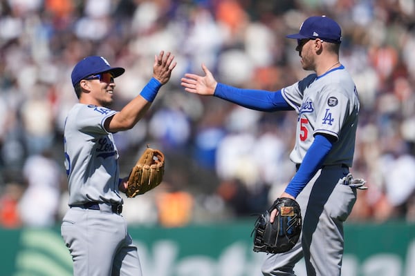 Los Angeles Dodgers' Tommy Edman, left, celebrates with Freddie Freeman after a baseball game against the San Francisco Giants in San Francisco, Sunday, July 13, 2025. (AP Photo/Jeff Chiu)