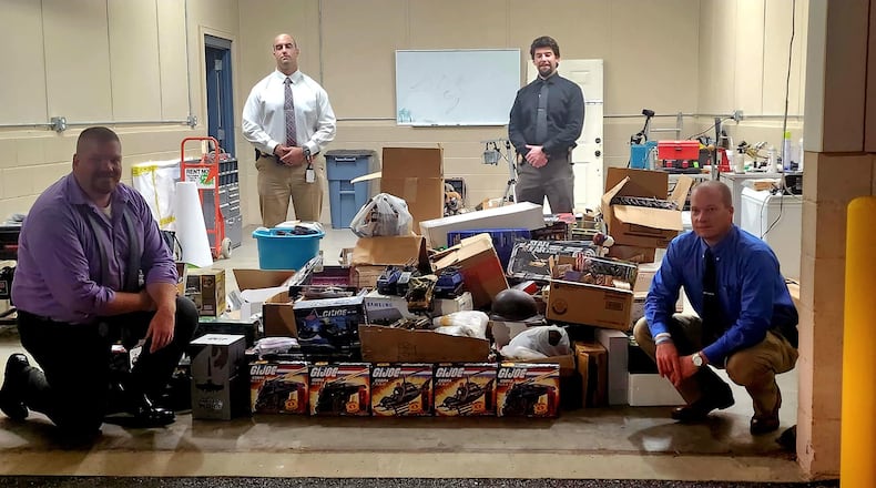 Investigators with the Coweta County Sheriff's Office pose with toys recovered after searching a house where suspects were believed to be selling items stolen in two recent burglaries.