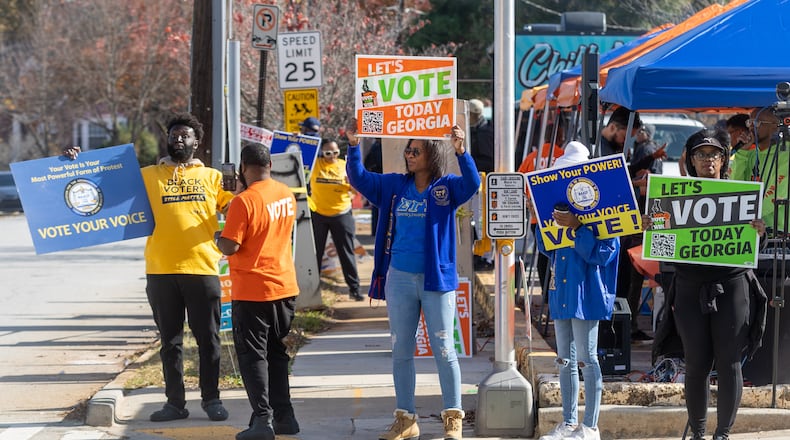 People wave signs to encourage early voting near the Metropolitan Library in Atlanta during early voting on Saturday, Nov. 26, 2022. (Photo: Steve Schaefer / steve.schaefer@ajc.com)