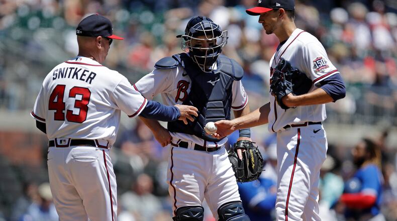 Atlanta Braves' Brian Snitker (43) takes the game ball from Charlie Morton in the fifth inning of a baseball game against the Toronto Blue Jays Thursday, May 13, 2021, in Atlanta. (AP Photo/Ben Margot)