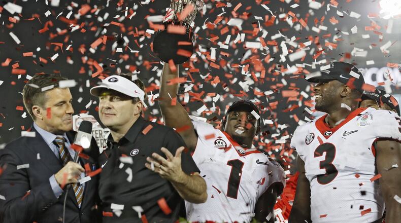 Georgia Bulldogs running back Sony Michel (1) holds the Rose Bowl trophy next to Georgia Bulldogs linebacker Roquan Smith (3) and coach Kirby Smart after the College Football Playoff Semifinal at the Rose Bowl Game on Jan. 1, 2018, in Pasadena, Calif. BOB ANDRES / BANDRES@AJC.COM