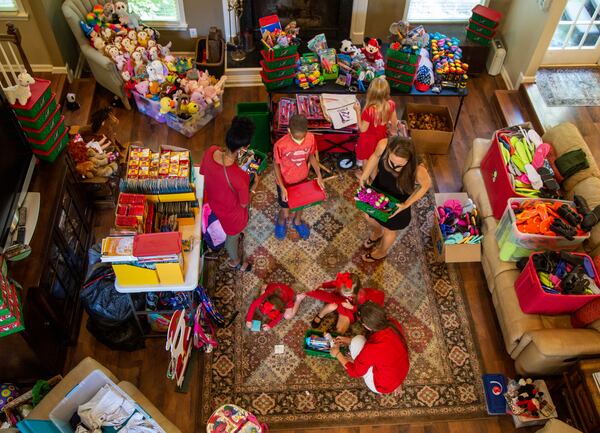 Volunteers prepare dozen items for packing at the home of Marika and Michael Chasse in Johns Creek. For the past six years, the Chasses have hosted a packing party for Operation Christmas Child shoeboxes, a project of Samaritan's Purse. Friends and neighbors will help pack 1,000 shoeboxes. PHIL SKINNER FOR THE ATLANTA JOURNAL-CONSTITUTION.