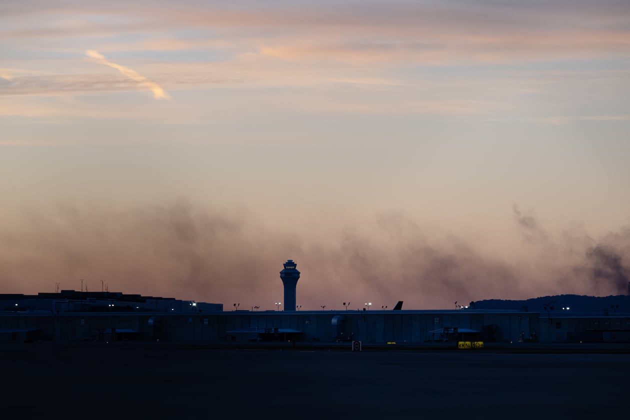 The air traffic control tower is seen on Wednesday, Nov. 5, 2025, while smoke rises from the crash site of UPS flight 2976 near Louisville Muhammad Ali International Airport in Louisville, Ky. (Jon Cherry/AP)