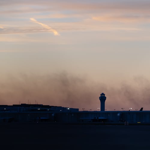 CORRECTS FLIGHT NUMBER The ATC tower is seen while smoke rises from the crash site of UPS Flight 2976 near Louisville Muhammad Ali International Airport on Wednesday, Nov. 5, 2025, in Louisville, Ky. (AP Photo/Jon Cherry)