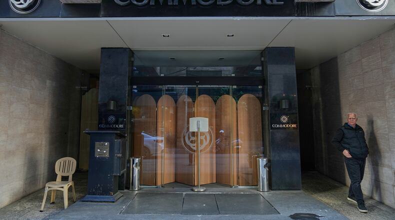 A man stands in the closed main entrance of the Commodore hotel, in Beirut, Lebanon, Sunday, Jan. 11, 2026. (AP Photo/Hussein Malla)