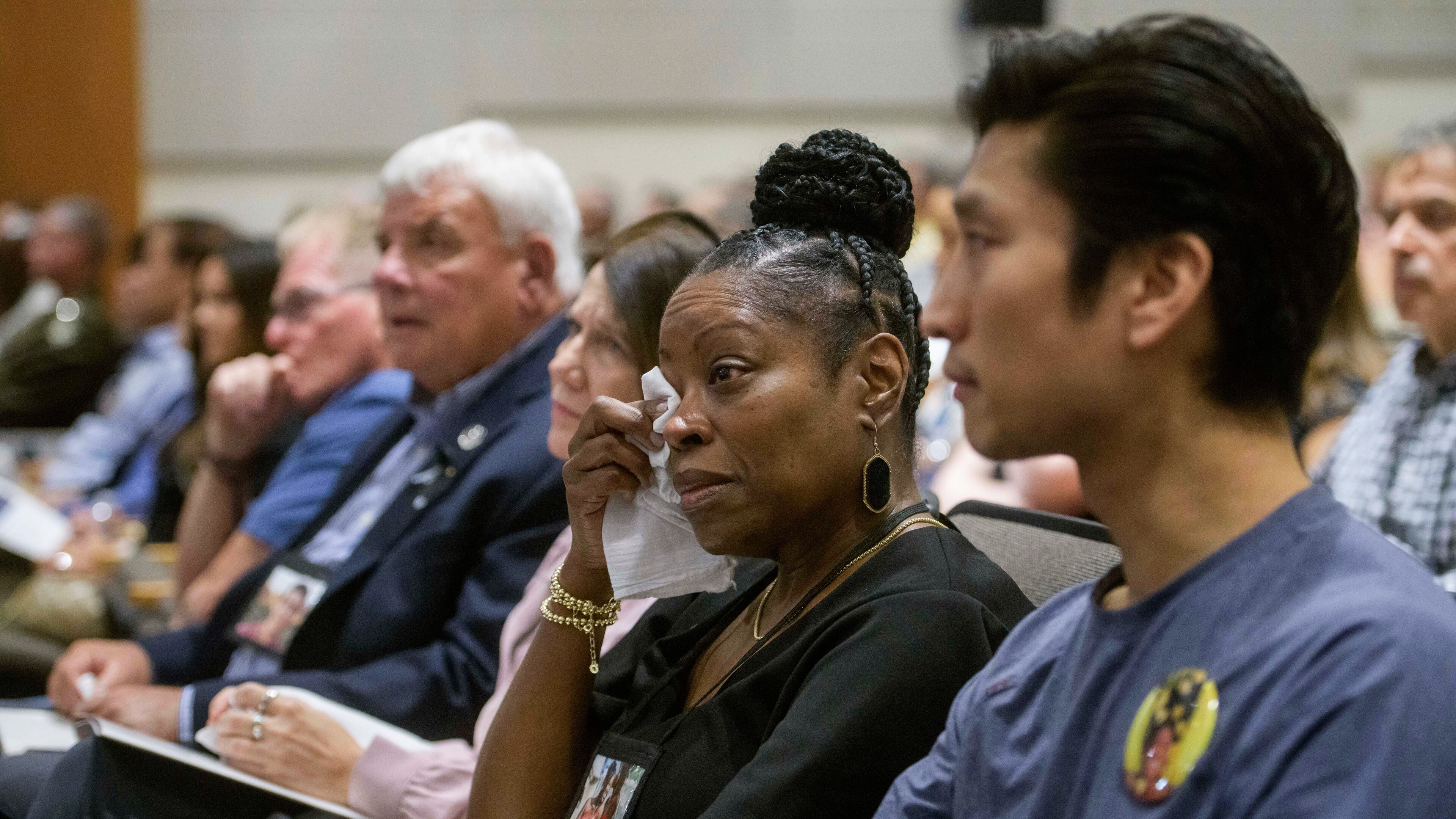 Gwen Duggins, second from right, whose daughter Kiah Duggins perished on American Airlines flight 5342 in a collision with a U.S. military helicopter, wipes the tears from her eyes while listening to the audio of the flight radio transmissions during the NTSB fact-finding hearing on the DCA midair collision accident, at the National Transportation and Safety Board boardroom, Wednesday, July 30, 2025, in Washington. (AP Photo/Rod Lamkey, Jr.)