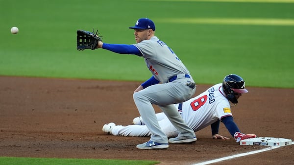 Atlanta Braves' Alex Verdugo (8) makes it back to first base against Los Angeles Dodgers first baseman Freddie Freeman (5) in the first inning of a baseball game, Sunday, May 4, 2025, in Atlanta. (AP Photo/Mike Stewart)