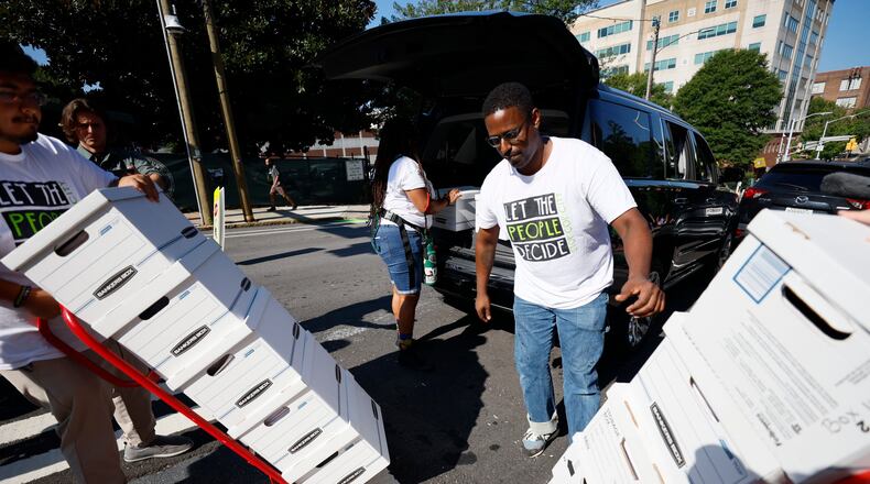 Forest defenders assisted in unloading sixteen boxes containing more than 100,000 signatures from a petition. They planned to submit this petition at City Hall on Monday, Sept. 10, 2023, to have the matter of the training center included in an upcoming ballot. (Miguel Martinez/AJC)