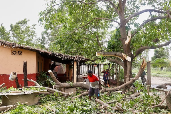 Residents remove debris after the passing of Hurricane Erick, near Charco Redondo, Oaxaca state, Mexico, Thursday, June 19, 2025. (AP Photo/Luis Alberto Cruz)