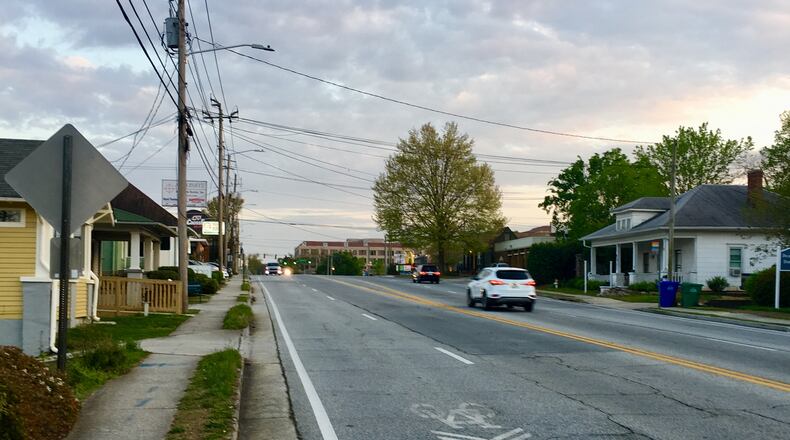 This is the portion of Church Street that will be narrowed from four to two lanes with wider sidewalks, protected bike lanes on each side and elimination of the “sharrow” lane on the left. This is looking south from the cemetery entrance towards Commerce Drive. Bill Banks for the AJC