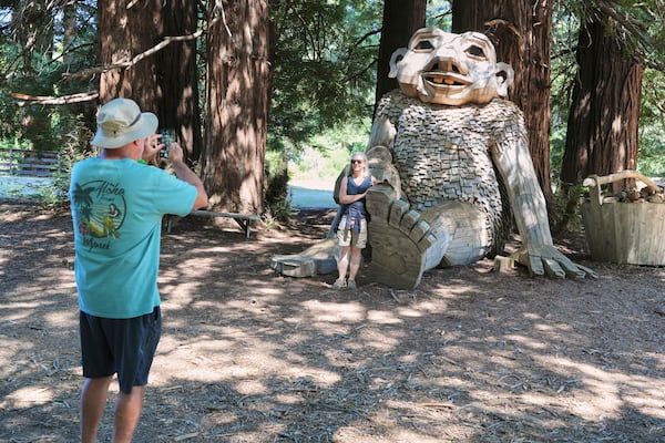 People take pictures alongside a giant troll sculpture created by the Danish recycle artist Thomas Dambo and his team that's part of an installation of six sculptures called "Trolls Save the Humans" on display at the historic estate Filoli, Saturday, July 5, 2025, in Woodside, Calif. (AP Photo/Terry Chea)