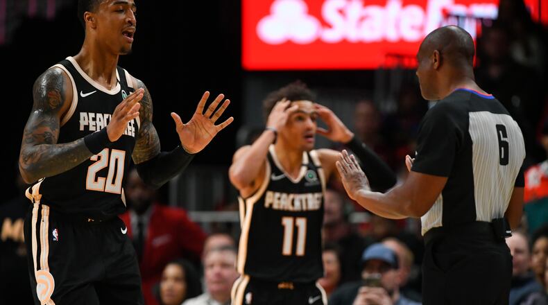 Hawks forward John Collins (20) and guard Trae Young (11) react to a technical foul called against Young by a referee during the first half against the Toronto Raptors, Monday, Jan. 20, 2020, at State Farm Arena in Atlanta.
