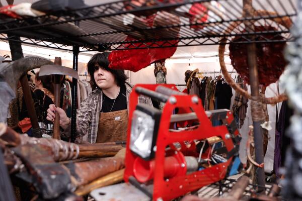 Sloan Salinas, one of the rotten pumpkin performers in the scare zone "The Rotten Ones" searches for props in the dressing room at Six Flags Over Georgia on Friday, Sept. 26, 2025. (Natrice Miller/AJC)