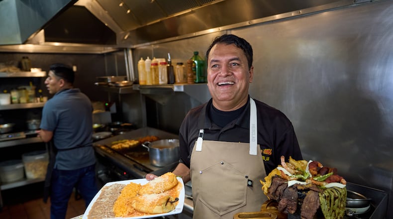 Mexican restaurant owner-chef Marco Mendoza prepares a hot molcajete, a traditional Mexican dish, at Cuernavaca's Grill in downtown Los Angeles, Tuesday, April 28, 2026. (AP Photo/Damian Dovarganes)