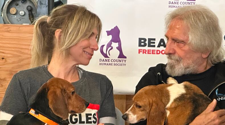 Pop star Debbie Gibson and Black Sabbath co-founder Terry "Geezer" Butler hold beagles that were purchased from a Dane County animal research facility on Tuesday, May 12, 2026, in Madison, Wis. (AP Photo/Scott Bauer)