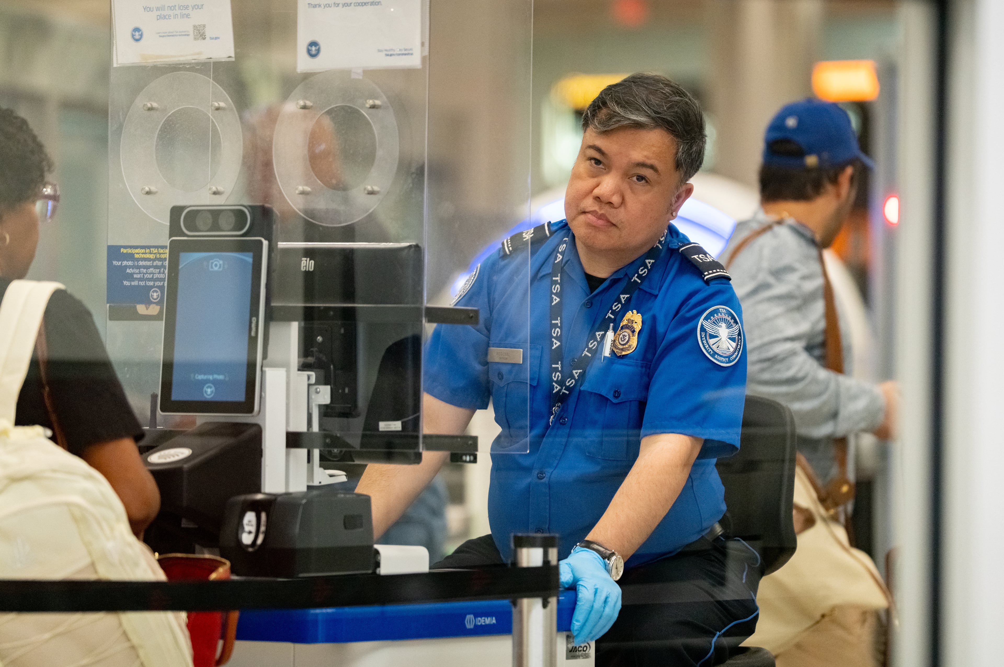 A Transportation Security Administration Agent checks the identification of travelers at Hartsfield-Jackson Atlanta International Airport.