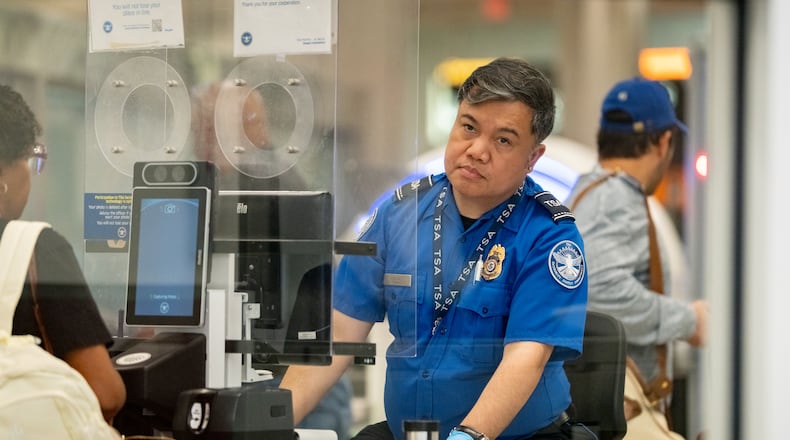 A TSA officer checks the identification of travelers at Hartsfield-Jackson Atlanta International Airport on Oct. 01, 2025 (Ben Hendren for the AJC)