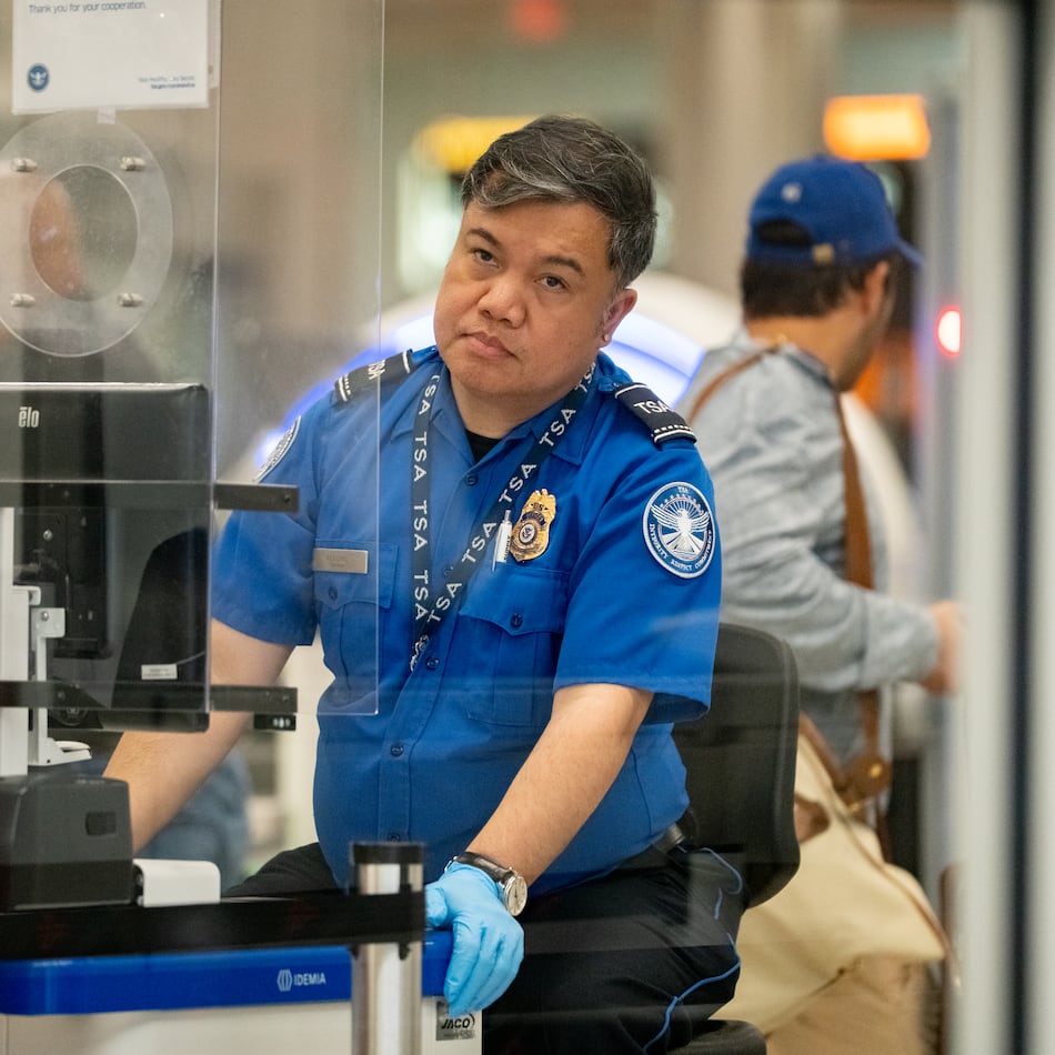 A TSA officer checks the identification of travelers at Hartsfield-Jackson Atlanta International Airport on Oct. 01, 2025 (Ben Hendren for the AJC)