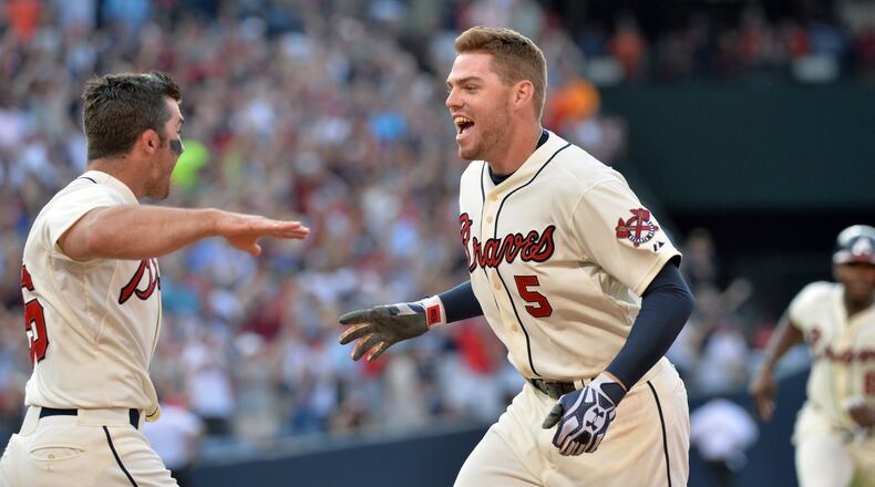 Braves first baseman Freddie Freeman (5) is congratulated by Atlanta Braves second baseman Dan Uggla (left) after his game winning single in the 9th inning against the San Francisco Giants at Turner Field in Atlanta on Saturday, June 15, 2013. Atlanta Braves won 6-5 over the San Francisco Giants.