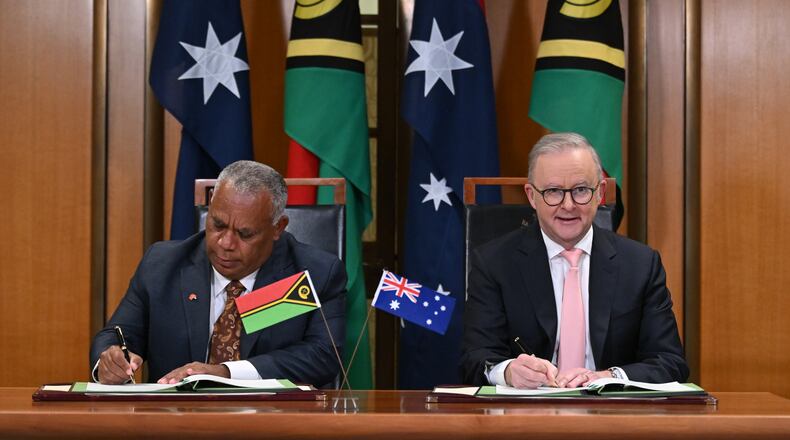 Prime Minister of Vanuatu Jotham Napat, left, and Australian Prime Minister Anthony Albanese sign the Nakamal agreement at Parliament House in Canberra, Monday, June 29, 2026. (Lukas Coch/AAP Image via AP)