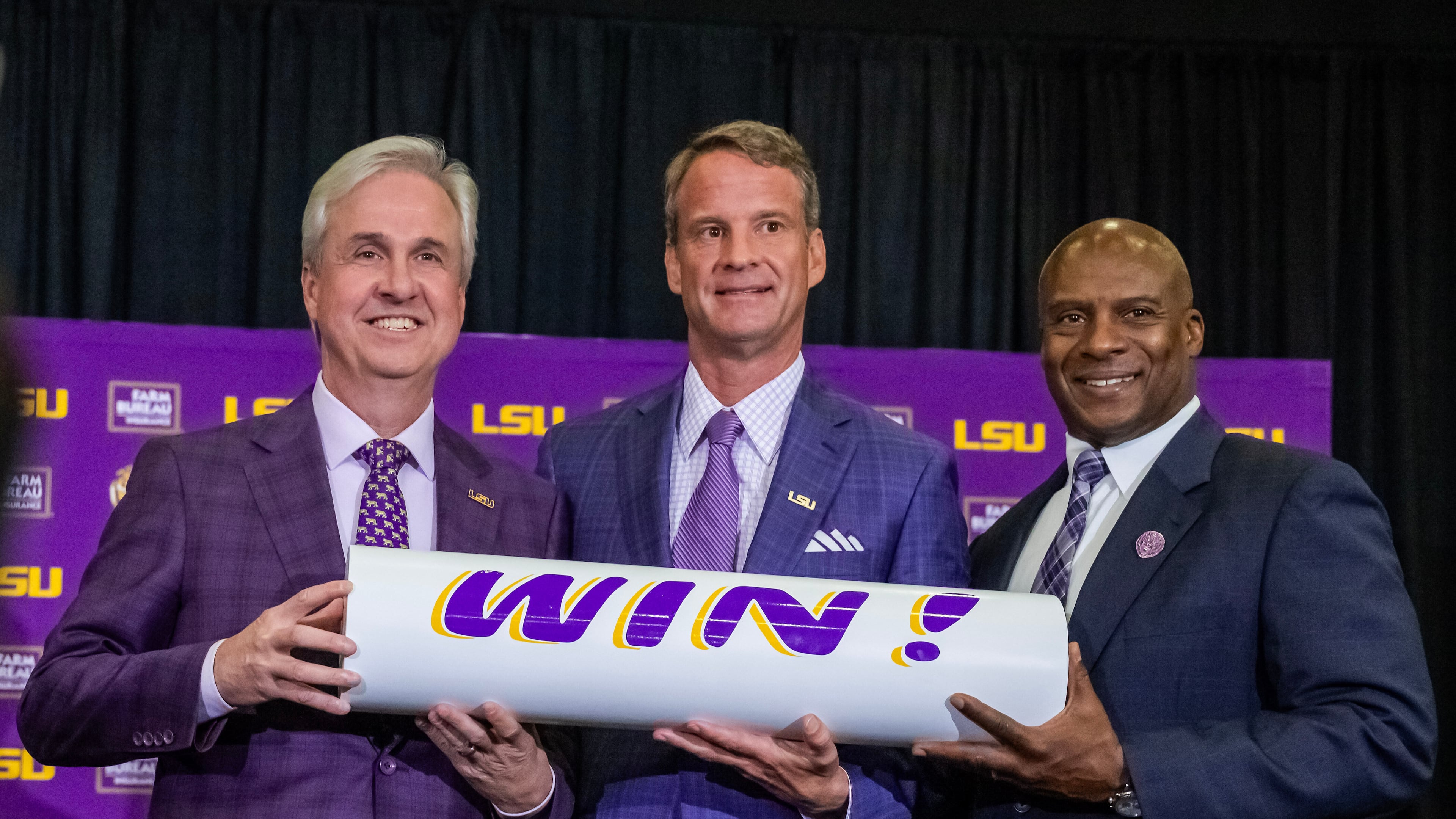 LSU president Wade Rousse, left, and athletic director Verge Ausberry, right, pose with new head football coach Lane Kiffin after after an introductory news conference, Monday, Dec. 1, 2025, in Baton Rouge, La. (Michael Johnson/The Advocate via AP)