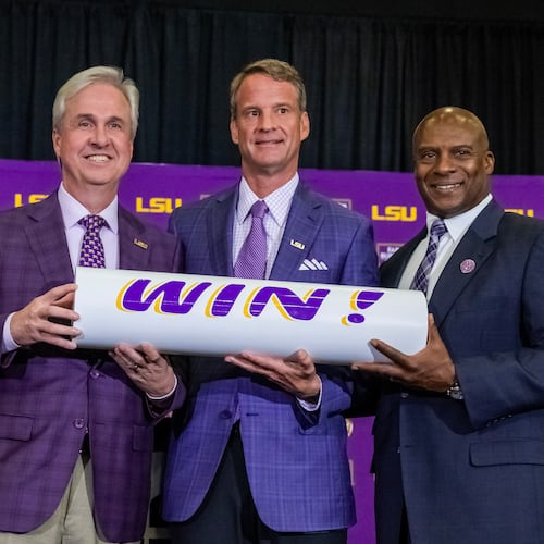 LSU president Wade Rousse, left, and athletic director Verge Ausberry, right, pose with new head football coach Lane Kiffin after after an introductory news conference, Monday, Dec. 1, 2025, in Baton Rouge, La. (Michael Johnson/The Advocate via AP)