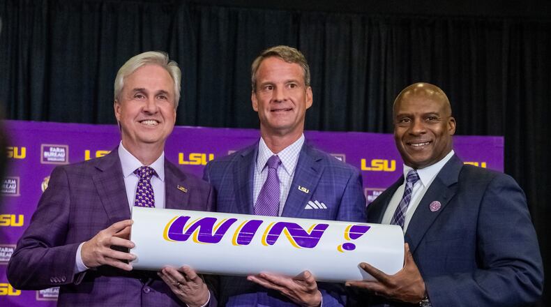 LSU president Wade Rousse, left, and athletic director Verge Ausberry, right, pose with new head football coach Lane Kiffin after after an introductory news conference, Monday, Dec. 1, 2025, in Baton Rouge, La. (Michael Johnson/The Advocate via AP)